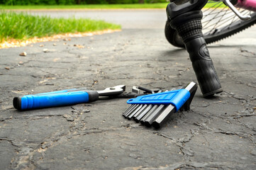 Tools and accessories set, screwdriver set on ground next to bicycle for repairing 