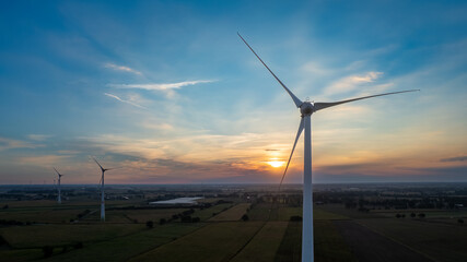 Wind farm with wind Turbine in a rural area against the sunset seen from an aerial view shot by a...