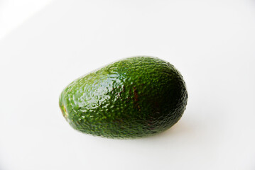 Green avocado fruit on a white background. Juicy avocado fruit close-up.
