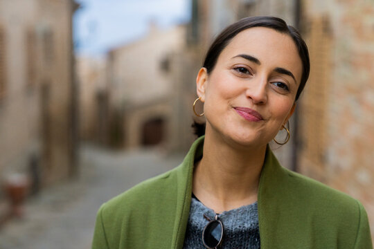 Happy ethnic woman walking along street