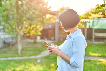 Woman in glasses using smartphone, type messages on mobile phone