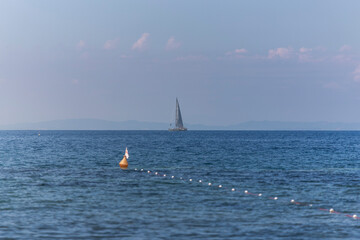 View of a yacht sailing along the coast on Elba Island, Tuscany, Italy.
