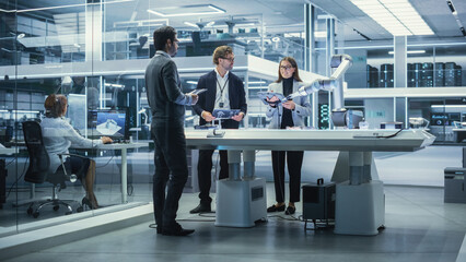 Young Team of Multicultural Engineers Use Tablet Computer, Analyze and Discuss How a Futuristic...