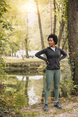 Fototapeta na wymiar Black Woman Before Jogging Near The River In Nature