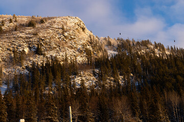 Beautiful ski slope in Funasdalen, Sweden with ski lift, gondola going up the hill surrounded by forest on a sunny winter day. Skiing resort in Sweden, Funasdalen covered in snow © Boumenjapet