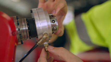 Male engineer doing maintenance robot arm at factory. He checking the operation of robot arm. Technology, automation, innovation and engineering concept.