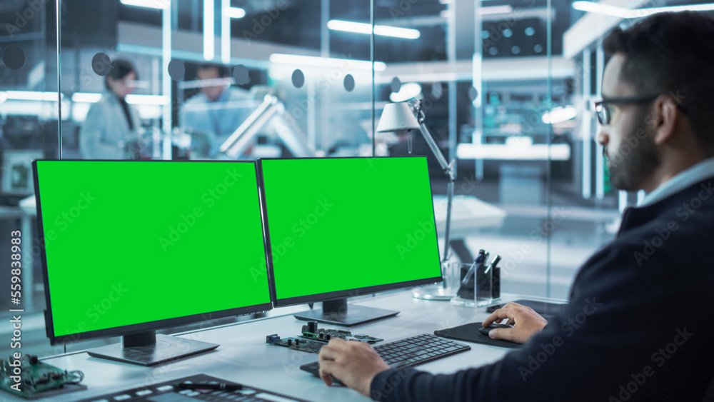 Aufkleber Software Developer Working on a Desktop Computer with Two Green Screen Chromakey Display Screens in a Factory Facility. Modern Technological Research and Development Center.