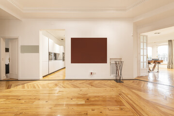 Empty exhibition room with red pine flooring with long varnished slats and access doors to other rooms in white wood and glass with white kitchen cabinets