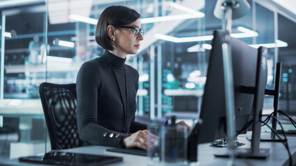 Adult Female Industrial Engineer Developing 3D Model of a Circuit Motherboard on Computer CAD...