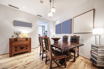 Living room with hardwood dining table with matching vintage wooden chairs, matching furniture and varnished pinewood parquet floors