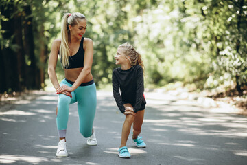 Mother with daughter jogging in park