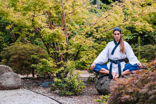 Female taekwondo master meditating in park