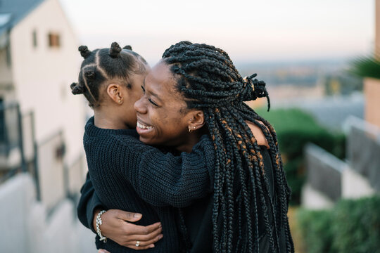 Happy black mother and daughter hugging outdoors