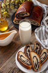 Roll with poppy seeds and a glass of milk. Food on the table. Sweet sweet pastries. Homemade simple yeast bun with filling. Breakfast on a wooden table. lactose and gluten. Honey spas