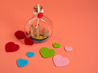 Ship in a bottle and hearts on a pink background.