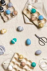 Colorful Easter eggs decoration, prepare for Happy Easter celebration, tape lace for decorating dyed chicken egg on table linen background. Lifestyle aesthetic photo at home, diy holiday