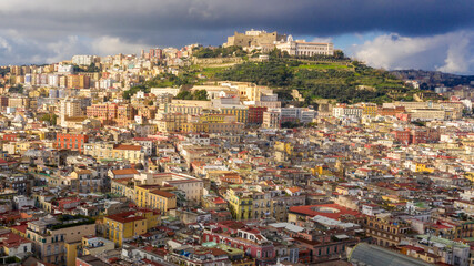 Fototapeta na wymiar Aerial view of Vomero hill and Castel Sant'elmo from the historic center of Naples, Italy. The sky is cloudly.