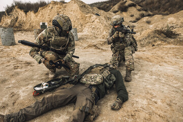 Soldiers near the wounded man examining him