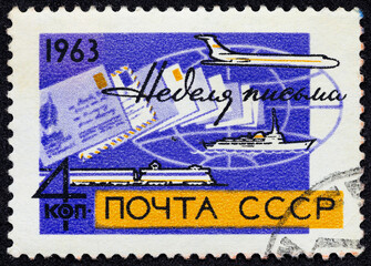 USSR - CIRCA 1963: Postage stamp 4 kopeck printed in the Soviet Union shows Plane, ship, train and envelopes on globe. Post stamp series devoted to International Letter Writing Week.