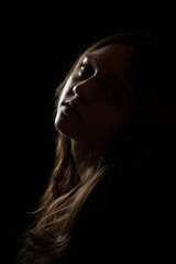 face of girl on a dark background with a back light