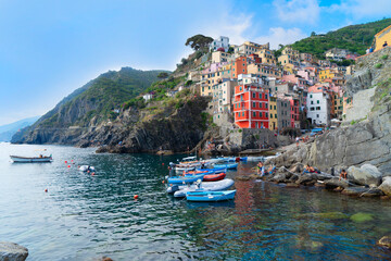 Fototapeta na wymiar Riomaggiore picturesque town with moored boats of Cinque Terre, Italy