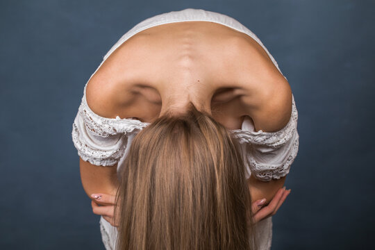 young girl showing off her beautiful shoulders - isolated on blue background