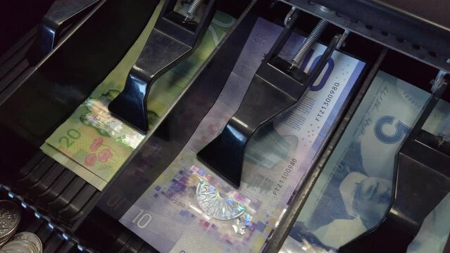 Close up of canadian money in register cash checkout business bills.