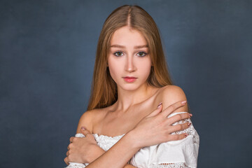 Fototapeta premium Portrait of a young beautiful blonde girl in white dress