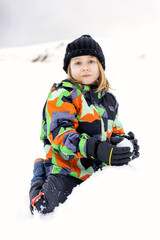 Fototapeta na wymiar little caucasian girl plays in the snow