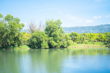 Fototapeta premium Green mountain hill with lake or river reflection. Nature landscape background, Thailand.