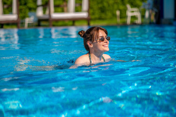 Dark-haired woman swimming in a swimming pool
