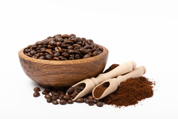 Ground coffee and coffee beans in wooden bowl and spoons isolated on white background.
