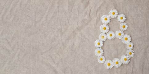 Figure eight of the daisy buds on a linen background. Isolate. Copy space. International Women Day background