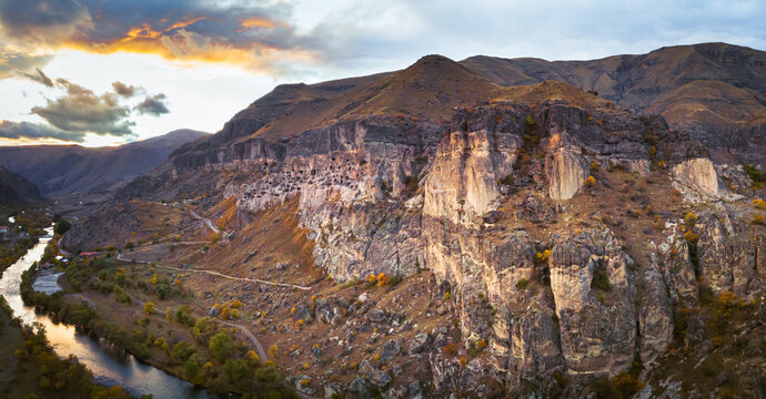 Dramatic aerial view to Vardzia cave city with paravani river and sunset in the background, Travel and sightseeing in Georgia.Unesco sites in caucasus. 2020