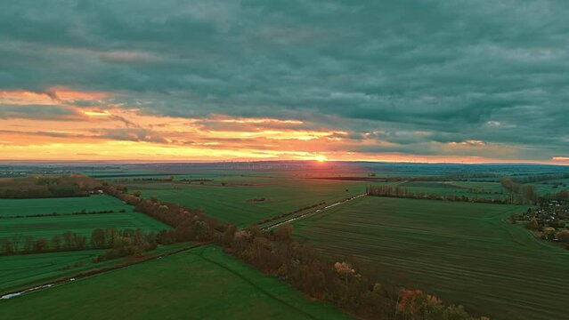 Drone shot of Golden Sunset and Cloudy Sky of green Fields in Oschersleben during twilight. Oschersleben is a town in the Börde district, in Saxony-Anhalt, Germany