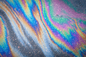 Fototapeta na wymiar Multi colored oil spill on asphalt road, abstract background