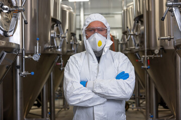 Brewery technologist standing between the fermentation tanks