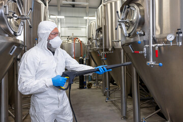 Experienced beer tech cleaning and sanitizing the brewing equipment