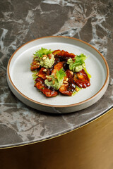 Grilled and glazed eel with guacamole  served on plate in restaurant