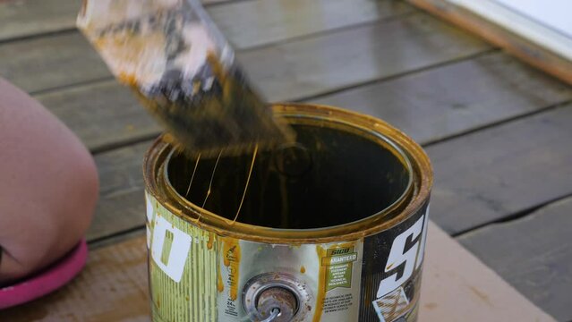 Woman dip a brush in paint dye painting dyeing housework slowmotion exterior