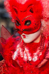 ritratto verticale di donna con maschera rosso fuoco e orecchie da gatto, tulle e vestito rosso