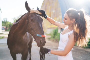 Obraz premium Woman scrubbing horse with brush on ranch