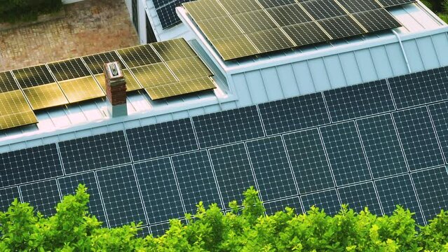 Aerial view of typical american building roof with blue solar photovoltaic panels for producing clean ecological electric energy. Investing in renewable electricity for retirement income concept