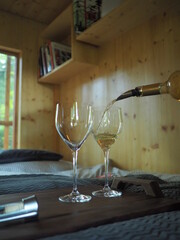Glass of wine on the bed in a wodden cottage