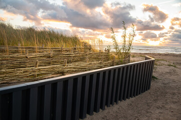 Metal fence with wicker fence for saving dunes. How to save dunes.