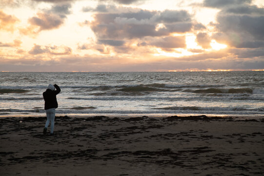 Photographer taking photos in sunset near the sea.