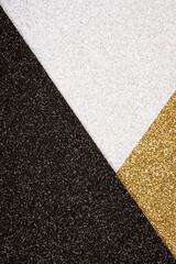 Festive abstract geometric glitter background in golden, black and silver colours with copy space. Minimal fashionable style backdrop. Luxury background. Vertical image