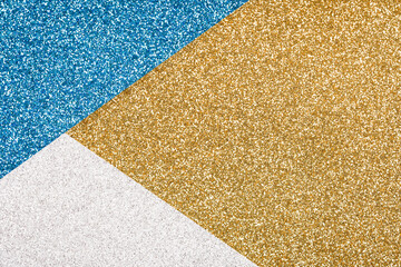 Festive glitter background in golden, blue and silver colours with copy space. Minimal fashionable style backdrop. Luxury background