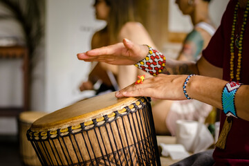 Sao Paulo, SP, Brazil - December 31 2022: Person with traditional Indian bracelets and rings playing djembe details.