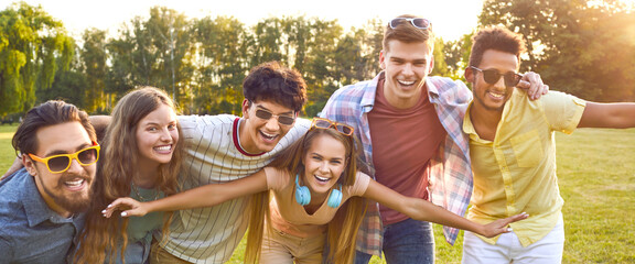 Happy, funny, positive friends hugging, looking at the camera and smiling. Diverse group of...